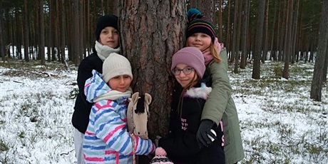 Powiększ grafikę: dziewczynki przytulają się do drzewa